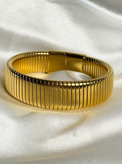 Gold bracelet on a white fabric background